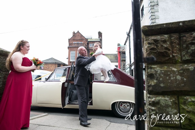 Flower girl being lifted out of wedding car in Wigton