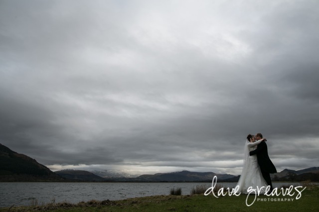 Bride and Groom standing on the shores of Bassenthwaite Lake, Cumbria